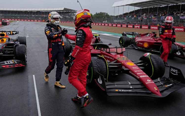 Pebalap Ferrari Carlos Sainz berjabat tangan dengan pebalap Red Bull Max Verstappen setelah sesi kualifikasi Grand Prix Inggris, Sirkuit Silverstone. (2/7/2022) 