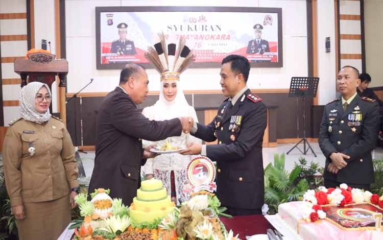 Kapolres Kotim AKBP Sarpani memberikan potongan tumpeng kepada salah seorang perwira dengan disaksikan Wakil Bupati Kotim Irawati, dan Dandim 1015 Sampit Letkol Inf Abdul Hamid
