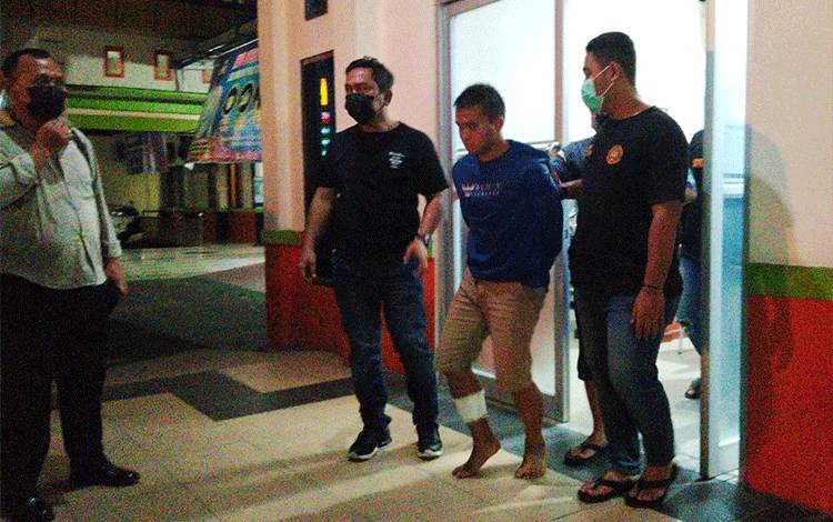 Petugas saat menggiring pelaku dari RS Bhayangkara Tingkat 3 Palangka Raya seusai pengobatan.