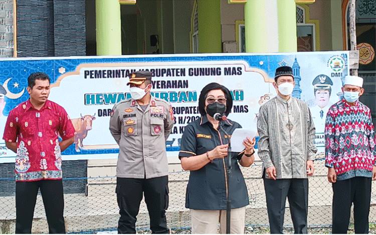 Wakil Bupati Gunung Mas Efrensia L.P Umbing saat membacakan sambutan dari Bupati Jaya S Monong di acara penyerahan secara simbolis hewan kurban yang dilaksanakan di halaman Masjid Darun Najah Kuala Kurun pada Sabtu 9 Juli 2022. (FOTO: RISKA YULYANA)
