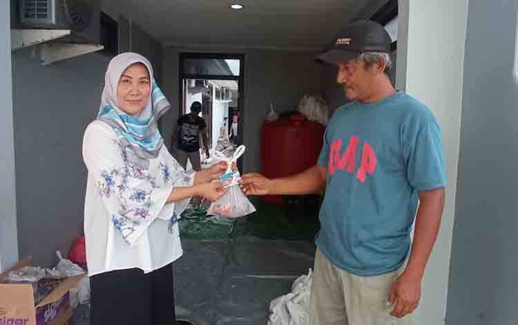 Pimpinan Perusahaan Borneonews- Palangka Post, Revi Apriani sedang menyerahkan daging kurban pada warga di Kantor Borneonews Jalan Pangeran Antasari, Pangkalan Bun, Kabupaten Kobar, Senin, 11 Juli 2022.