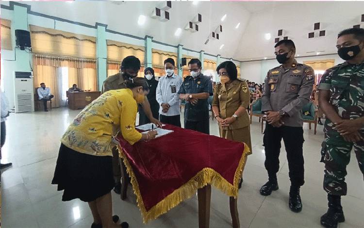 Salah satu calon Kades perempuan dari Desa Putat Durei yang bernama Sri Rayahu sedang menandatangani pakta integritas di hadapan Wakil Bupati Gunung Mas Efrensia L.P Umbing yang dilaksanakan pada Senin 11 Juli 2022. (FOTO: RISKA YULYANA)