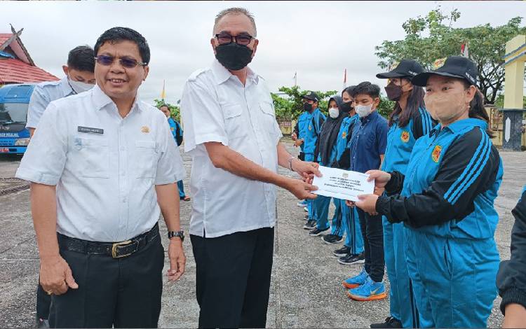 Disdikpora Kabupaten Gunung Mas menyerahkan bonus pada perwakilan atlet yang mendapatkan medali di Popprov Kalimantan Tengah di halaman kantor Disdikpora setempat pada Rabu 13 Juli 2022. (FOTO: RISKA YULYANA) 