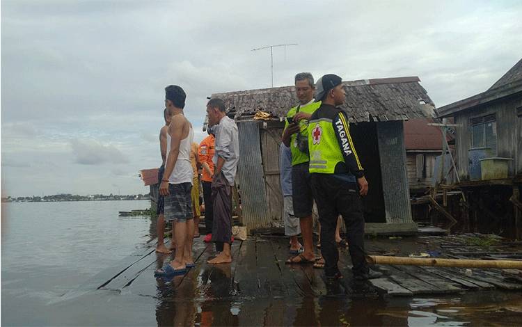  Sejumlah warga dan tim dari Tagana saat melihat sekitar lokasi perempuan tenggelam di Sungai Mentaya, Rabu, 13 Juli 2022. (Foto: HAMIM)