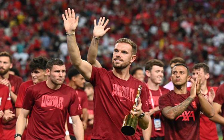 Kapten Liverpool Jordan Henderson memegang trofi laga persahabatan setelaj Liverpool menang 2-0 atas Crystal Palace di National Stadium, Kallang, Singapura, Jumat 15 Juli 2022. (REUTERS/CAROLINE CHIA)