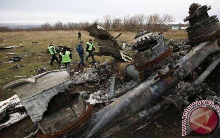 Penyelidik Belanda dan anggota Kementerian Darurat bekerja di lokasi jatuhnya pesawat Malaysia Airlines MH17 di dekat desa Hrabove, Donetsk, Ukraina timur, Minggu (16/11/2014). (REUTERS/Maxim Zmeyev)