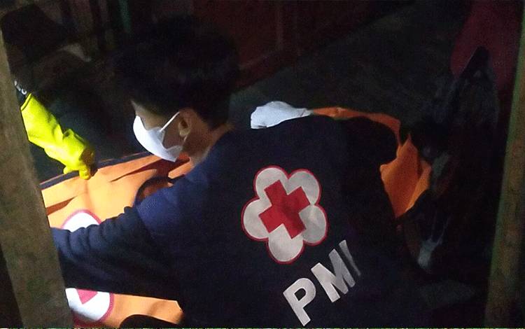 Seorang relawan PMI Kotim saat melakukan evakuasi terhadap jenazah pria yang ditemukan meninggal dunia di dalam rumahnya, Selasa malam, 19 Juli 2022. (FOTO: HAMIM)