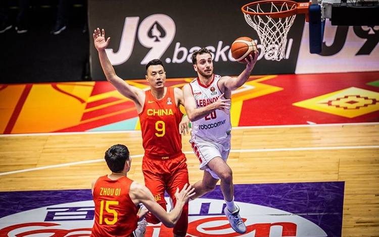 Kapten tim nasional bola basket Lebanon Wael Arakji (kanan) mencetak angka di hadapan dua pemain China Zhou Qi (bawah) dan Zhai Xiaochuan dalam pertandingan perempat final Piala FIBA Asia 2022 di Istora Gelora Bung Karno, Senayan, Jakarta, Rabu (20/7/2022). (ANTARA/HO-FIBA Asia)