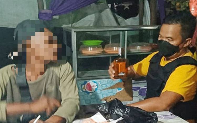 Plt Kasatpol PP Barito Timur Ari Panan P Lelu (kanan), sedang menegur pemuda mabuk yang mengamuk di warung, Sabtu, 23 Juli 2022. (FOTO: BOLE MALO)