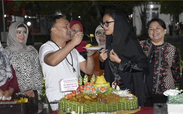 Gubernur Kalimantan Tengah, Sugianto Sabran pada saat memberikan potongan nasi tumpeng kepada istri tercinta, Ivo Sugianto Sabran (FOTO : MMC KALTENG) 