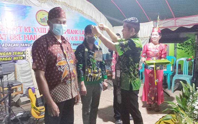 Bupati Barito Timur Ampera AY mengalungkan tanda pengenal kepada peserta Sidang Sinode ke-XXIII Resort GKE Tamiang Layang dalam pembukaan kegiatan tersebut, Jumat, 29 Juli 2022. (FOTO: BOLE MALO)