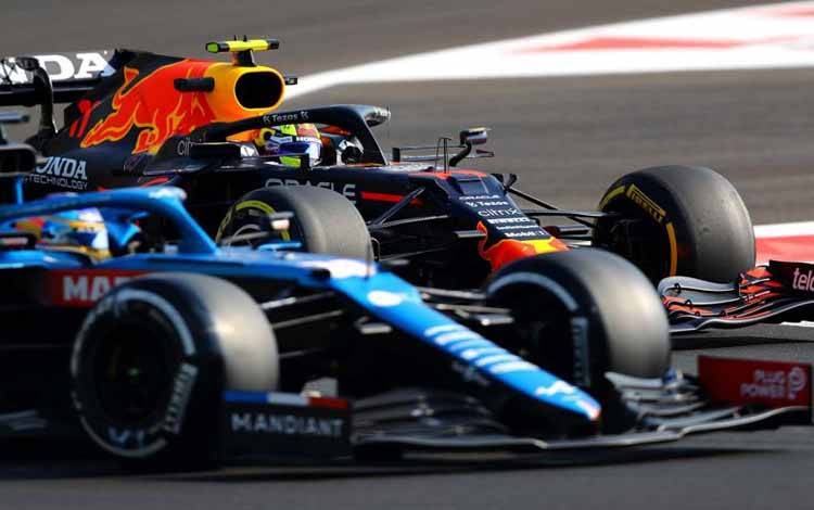 Pebalap Formula One Alpine Fernando Alonso dan Red Bull Sergio Perez terlihat saat latihan Abu Dhabi Grand Prix di Yas Marina Circuit, Abu Dhabi, Uni Emirat Arab, Sabtu (11/12/2021). ANTARA FOTO/REUTERS/Ahmed Jadallah/aww/cfo (REUTERS/AHMED JADALLAH)