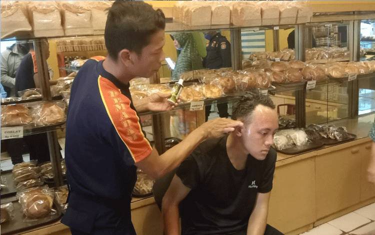 Petugas Damkar Kobar memberikan pertolongan pertama pada korban luka bakar yang terjadi di toko roti yang berlokasi di Kelurahan Raja, Pangkalan Bun, Kabupaten Kobar, Rabu, 3 Agustus 2022. (FOTO: YUDHA)