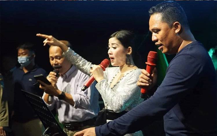 Bupati Lamandau Hendra Lesmana hadir dan naik ke panggung bernyanyi dengan artis dangdut, Nasya Aqila. (FOTO : HENDI NURFALAH)