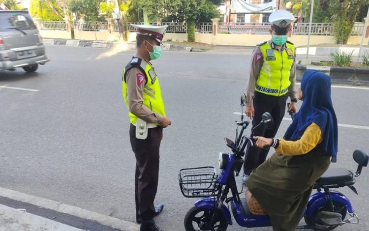 Personel Satlantas Polres Kapuas saat tegur warga pengguna sepeda listrik tanpa menggunakan kelengkapan keselamatan. (FOTO: POLRES KAPUAS)