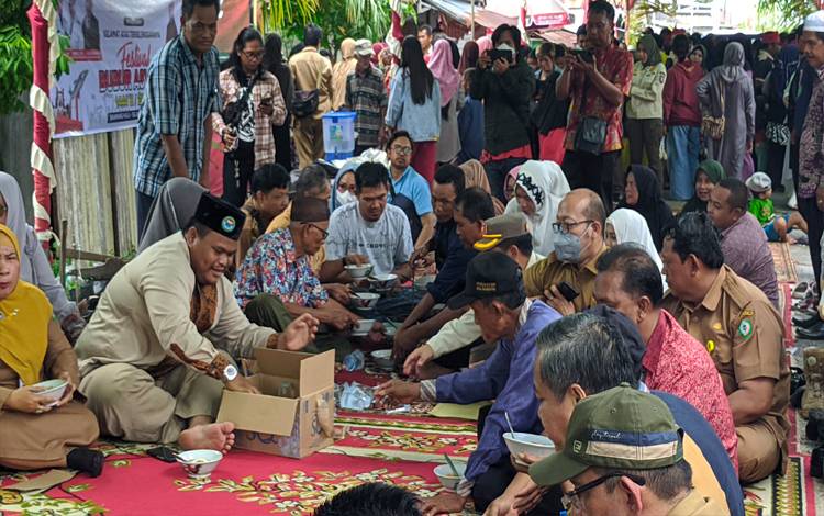 Sejumlah warga saat makan bubur asyura bersama-sama, di Festival Bubur Asyura, di Kelurahan Baamang Hulu, Kecamatan Baamang, Sampit, Selasa, 9 Agustus 2022