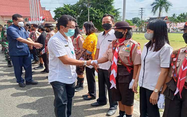 Sekretaris Daerah Barito Timur Panahan Moetar menyalami anggota kontingen Jambore Nasional XI usai upacara pelepasan di Halaman Kantor Bupati Barito Timur, Rabu, 10 Agustus 2022. (FOTO: BOLE MALO)