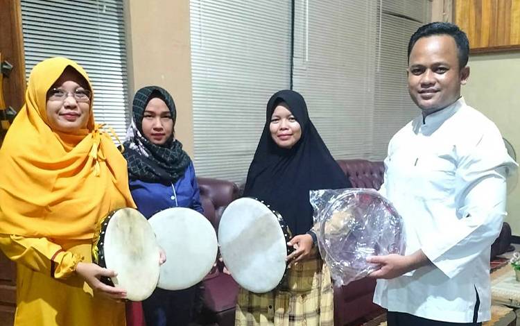 Ketua DPRD Barito Timur Nursulistio saat menyerahkan bantuan alat musik untuk Grup Rebana Ibu-Ibu Desa Tangkum. (FOTO: BOLE MALO)