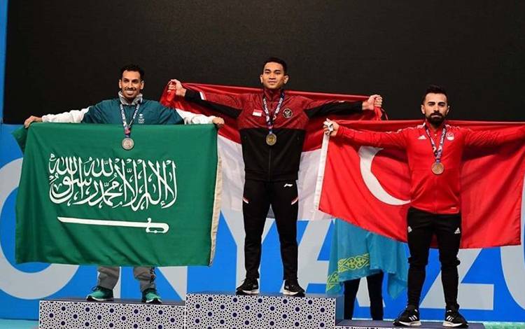 Lifter Indonesia Ricko Saputra (tengah) berpose setelah meraih medali emas dari cabang olahraga angkat besi kelas 61kg putra pada Islamic Solidarity Games 2021 di Konya, Turki, Jumat (12/8/2022) (ANTARA/ISG Photo)