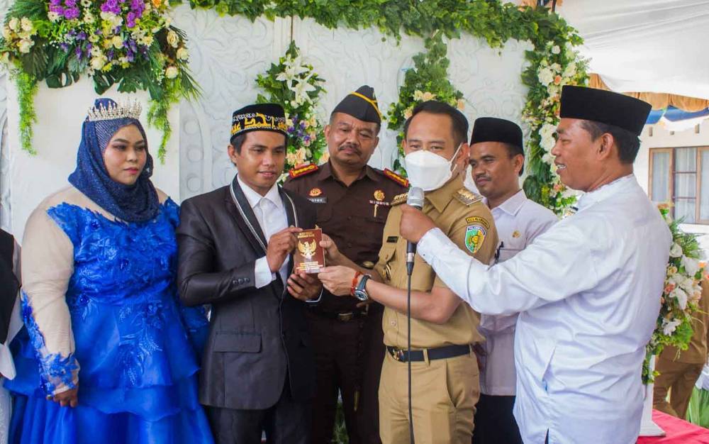 Wali Kota Palangka Raya Fairid Naparin menyerahkan buku nikah untuk peserta nikah massal. (FOTO: HENDRI)