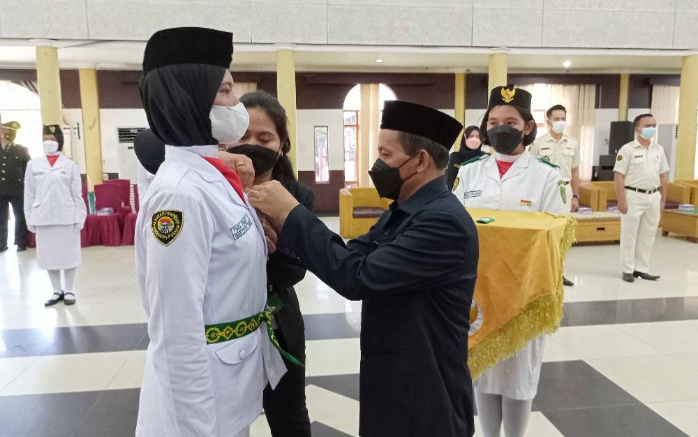 Wakil Bupati Barito Timur Habib Said Abdul Saleh menyematkan lencana merah putih garuda dan kendhit kepada anggota Paskibraka saat upacara pengukuhan, Senin, 15 Agustus 2022. (FOTO: BOLE MALO)