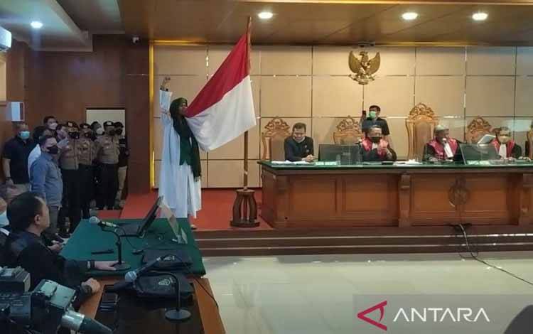 Terdakwa kasus ujaran bohong Bahar Smith mencium bendera Merah Putih usai mendengarkan putusan di Pengadilan Negeri Bandung, Kota Bandung, Jawa Barat, Selasa (16-8-2022). ANTARA/Bagus Ahmad Rizaldi