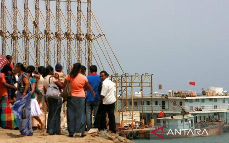 Arsip - Warga Sri Lanka menyaksikan kapal pengeruk China bekerja di Hambantota, 240 km tenggara Kolombo, 24 Maret 2010. (ANTARA/Reuters/Andrew Caballero-Reynolds/as)