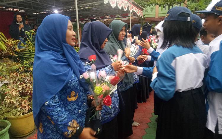 Siswa-siswi SMPN 2 Sampit saat menyerahkan setangkai bunga kepada para guru, Rabu, 17 Agustus 2022. (FOTO: NISA)