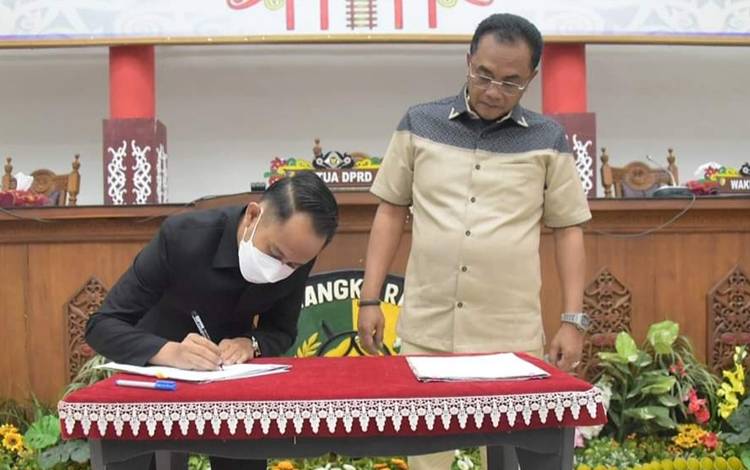 Wali Kota Palangka Raya, Fairid Naparin menandatangani nota kesepakatan seusai paripurna hasil reses. (FOTO: HUMAS PEMKO)