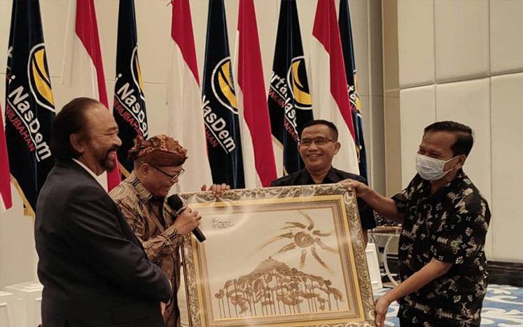 Ketua Umum DPP Partai NasDem Surya Paloh saat menerima lukisan dari para Guru Besar dari sejumlah perguruan tinggi, di NasDem Tower, Jakarta, Jumat (19/8/2022). (ANTARA/HO-DPP NasDem)