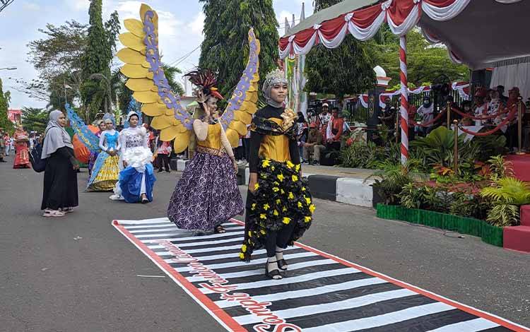 Sejumlah peserta Pawai Pembangunan di Kotim saat menampilkan kostum buatan mereka di hadapan panggung Bupati Kotim dan pejabat daerah lainnya. (FOTO: HAMIM)