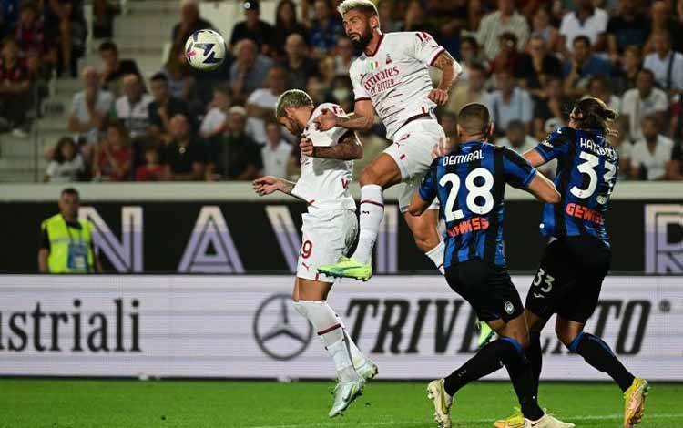 Penyerang AC Milan Olivier Giroud (kedua kiri) menyundul bola dalam pertandingan Liga Italia lawan Atalanta pada 21 Agustus 2022. ANTARA/AFP/MIGUEL MEDINA