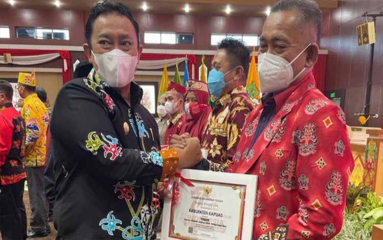 Wakil Gubernur Kalteng, Edy Pratowo menyerahkan penghargaan kepada Kabupaten Kapuas yang diwakili Kabid P2P Dinkes Kapuas dr Ahmad Haspiani di Kota Palangka Raya, baru-baru ini. (FOTO: IST)