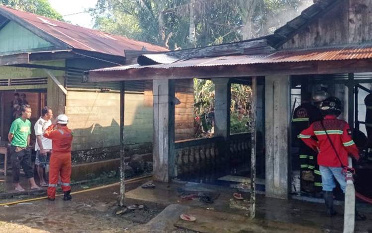 Petugas pemadam saat memadamkan kebakaran rumah warga di RT 10 Kelurahan Ampah Kota, Kamis 1 Agustus 2022. (FOTO: BPK SAMUJA)