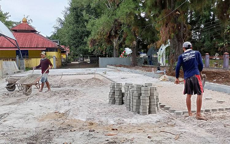 Para pekerja sedang memasang paving block di RTH Tamiang Layang, Sabtu, 3 September 2022. (FOTO: BOLE MALO)