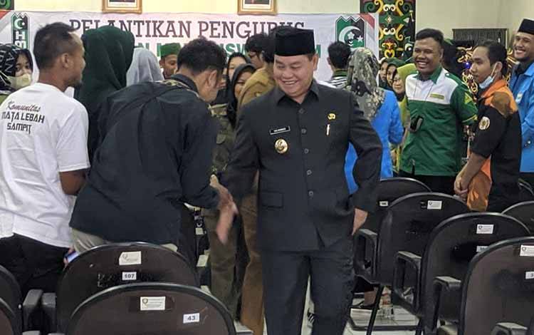 Bupati Kotim Halikinnor saat berjabat tangan dengan sejumlah mahasiswa di Sampit, usai menghadiri kegiatan beberapa waktu lalu. (FOTO: HAMIM)