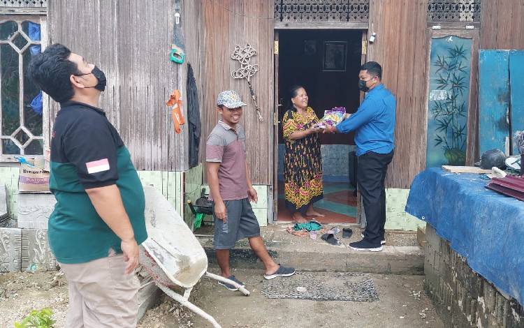 Kasat Narkoba Polres Gunung Mas Iptu Budi Utomo menyerahkan bantuan sembako kepada sejumlah warga di Desa Petak Bahandang Kecamatan Kurun pada Selasa 6 September 2022. (FOTO: HUMAS POLRES GUMAS) 