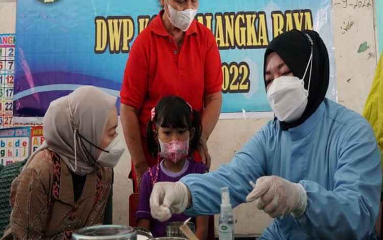 Penasehat Dharma Wanita Persatuan Kota Palangka Raya, Avina Fairid Naparin saat mendampingi imunisasi anak. (FOTO: DISKOMINFO)