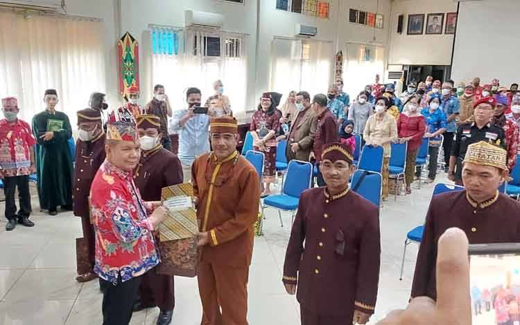 Bupati Kapuas Ben Brahim S Bahat menyerahkan SK kepada Damang Kepala Adat Kecamatan Selat, Manli D Apil. (FOTO: DODI)