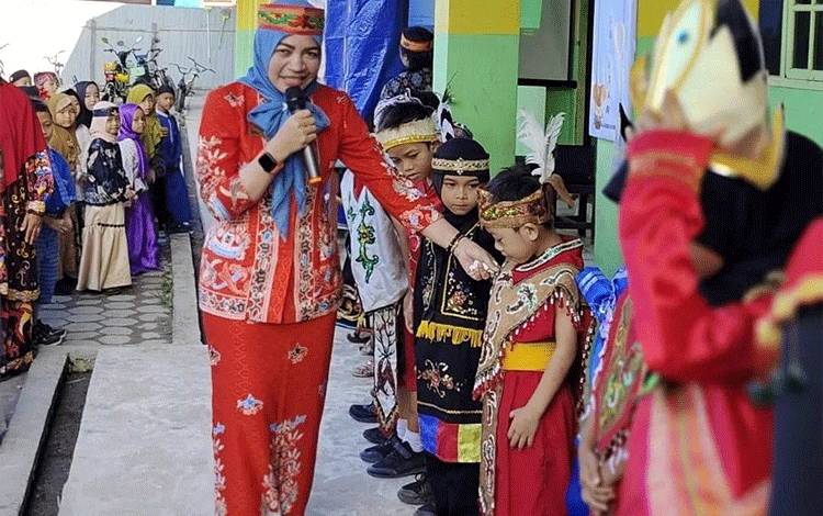 Pengawas SD UPT Kecamatan Baamang Rusnilawati saat menjelaskan bahan pakaian adat kepada siswa-siswi (Foto: M ANDHIKA)