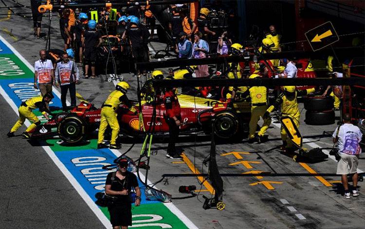 Para mekanik Ferrari mendorong mobil Charles Leclerc di jalur pit saat sesi latihan bebas ketiga Grand Prix Italia, Sirkuit Monza. (10/9/2022) (AFP/MIGUEL MEDINA)