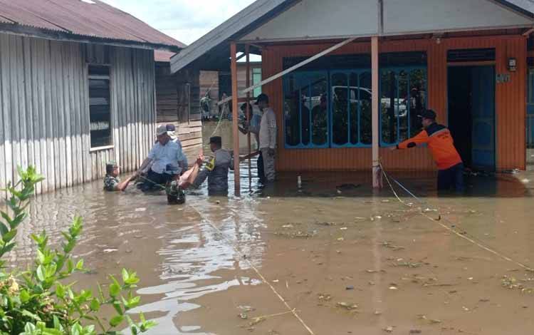 Sejumlah anggota polisi bersama TNI, dan pegawai BPBD Kotim saat mendatangi sejumlah rumah warga yang dilanda banjir. Sementara, seorang balita laki-laki ditemukan tewas tenggelam ditengah kondisi banjir di Desa Bawan, Kecamatan Mentaya Hulu, Kotim