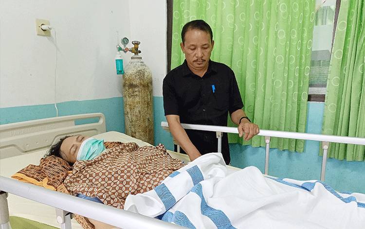 Wabup Barito Timur Habib Said Abdul Saleh menemani istrinya sesaat setelah dipindahkan dari ruang operasi ke ruang perawatan. (FOTO: BOLE MALO)