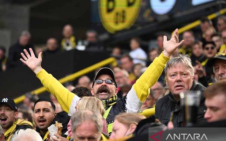 Arsip - Suporter Borussia Dortmund bereaksi saat mendukung tim kesayangannya menghadapi VfL Bochum dalam pertandingan Liga Jerman 2021-22 di Stadion Signal Iduna Park, Dortmund, Jerman, Sabtu (30/4/2022). (ANTARA/AFP/Ina Fassbender)