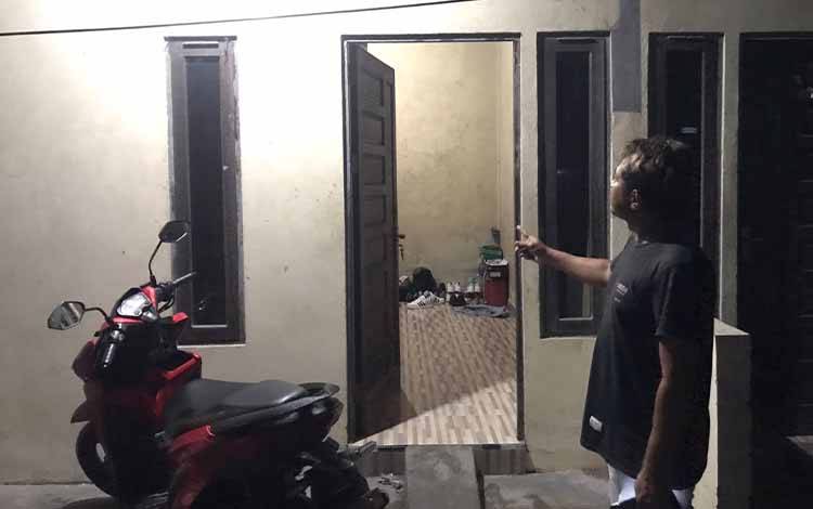 Suami korban perampokan menunjukkan pintu masuk kamar baraknya yang menjadi tempat perampok itu beraksi. (FOTO: HAMIM)