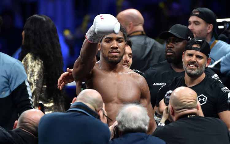 British boxer Anthony Joshua celebrates after winning the heavyweight boxing match between Andy Ruiz Jr. and Anthony Joshua for the IBF, WBA, WBO and IBO titles in Diriya, near the Saudi capital on December 7, 2019. - Ruiz seeks to win back the titles that he lost to Ruiz in a shock June defeat in New York in this high-profile duel , dubbed "Clash on the Dunes". (Photo by Fayez Nureldine / AFP) (AFP/FAYEZ NURELDINE)