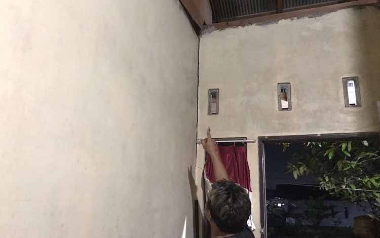 Suami korban saat menunjuk dugaan tempat pelaku masuk ke dalam rumahnya. (FOTO: HAMIM)