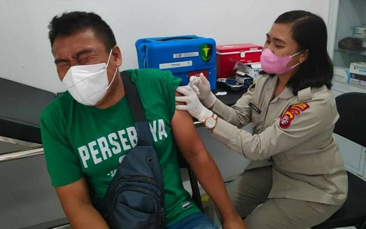 Petugas dari  Klinik Seksi Dokkes Polresta Palangka Raya memberikan vaksinasi dosis dua kepada masyarakat. (FOTO: TIM HUMAS POLRESTA PALANGKA RAYA)