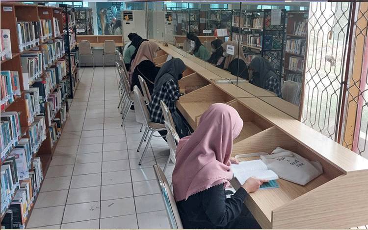 Pengunjung Perpustakaan Kalteng sedang membaca buku (FOTO : MMC KALTENG)