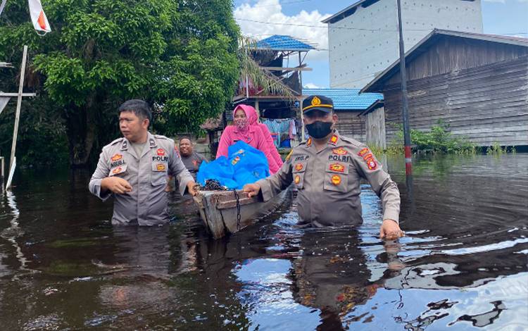 Kapolsek Katingan Hilir AKP Eko Priono menarik sampan membawa sembako untuk disalurkan kepada warga terdampak banjir di wilayah Kelurahan Kasongan Lama. (FOTO: ABDUL GOFUR)